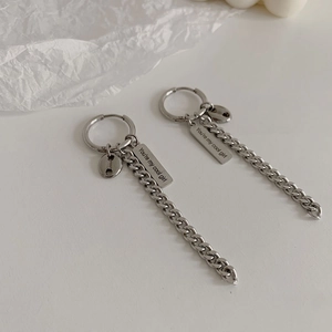 Detail of silver stainless steel drop earrings with long chain and engraved tag