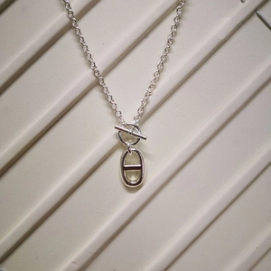 Macro shot of polished stainless steel anchor link pendant with classic toggle clasp