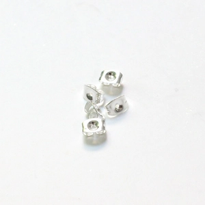 Macro view of four shiny silver stainless steel butterfly earring backs on white background