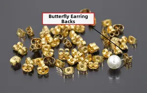 Golden butterfly earring backs displayed on a mirror surface for jewelry making