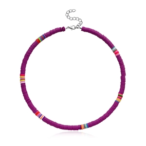 Macro detail of purple heishi clay beads and rainbow stripe accents on the choker necklace
