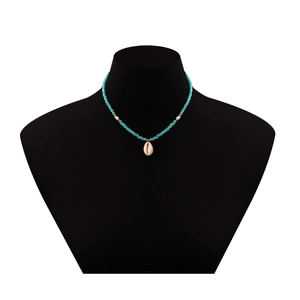 Dettaglio collana boho con perline turchesi e ciondolo a conchiglia su un busto nero