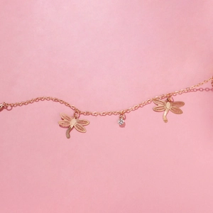 Detail of gold dragonfly anklet featuring hollow alloy charms and sparkling rhinestones