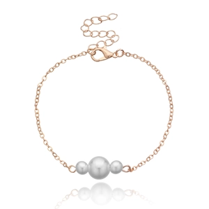 Detail eines rosévergoldeten Armbands mit drei weißen Perlen und sicherem Karabinerverschluss