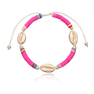 Detail eines handgefertigten Fußkettchens aus pinkfarbenen Heishi-Perlen mit goldenen Muscheln