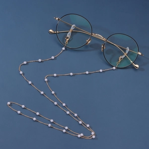 Detail of elegant gold eyewear chain featuring white pearls and secure lobster clasps