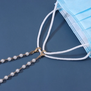 Elegant gold link chain with white pearls for face masks or glasses on blue background