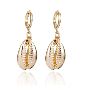 Gros plan de boucles d'oreilles coquillage dorées avec une texture détaillée
