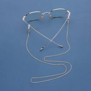 Golden snake chain eyewear holder with round glasses on a blue background