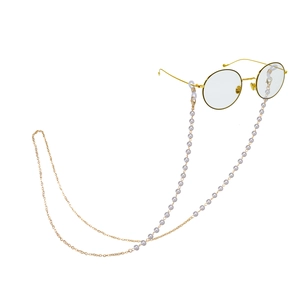 Elegant gold round glasses with pearl and chain strap accessory on white background
