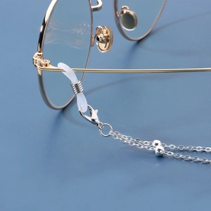 Chaîne à lunettes argentée avec perles et ailes d'ange et boucles en silicone blanc