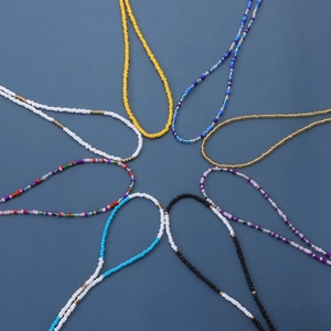 Macro view of colorful beaded chains in various patterns on a dark blue background