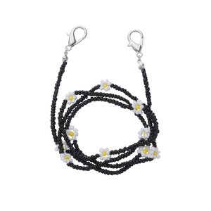 Detail of beaded glasses chain with black seed beads and white daisy flower charms
