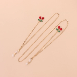 Detailed view of golden eyewear chain with red cherry charms and clear silicone loops