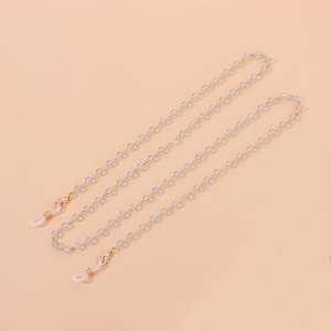 Détail de la chaîne dorée avec perles blanches mates et boucles pour lunettes