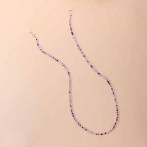 Chaînes de lunettes colorées en perles violettes et blanches sur fond rose