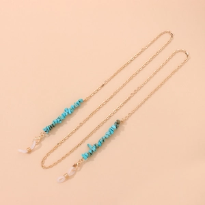 Détail de la chaîne à lunettes dorée avec pierres turquoise et boucles en silicone réglables