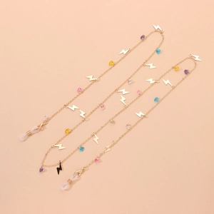 Detail of gold metal eyewear chain featuring colorful heart beads and lightning pendants