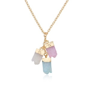 Detail of gold necklace with three irregular pastel gemstone pendants and metal edging