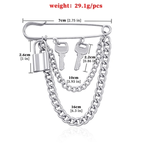 Silver punk style lock and key brooch with layered metal chains on a white background