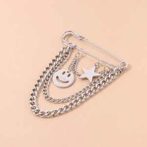 Silver layered chain brooch with smile pendant and textured star on a safety pin base
