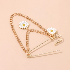 Gold-plated daisy chain brooch featuring white enamel flowers and a large safety pin accent