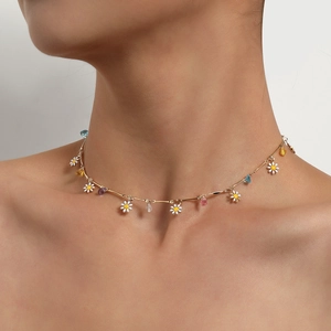 Goldene Halskette mit weißen Gänseblümchen-Anhängern und bunten Steinen am Model