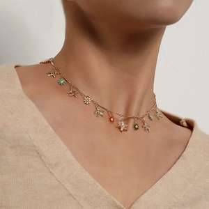 Hawaiian gold choker necklace featuring starfish and colorful enamel daisy charms on model
