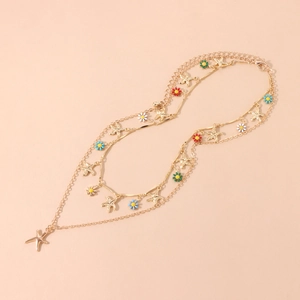 Detail of gold starfish pendants and colorful enamel daisy charms on a multi-layer chain