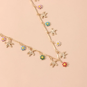 Detail of golden link chain necklace featuring colorful enamel flowers and starfish charms