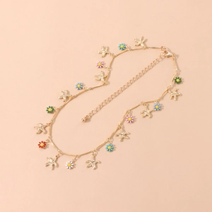 Detail view of golden necklace with colorful enamel flowers and starfish charms
