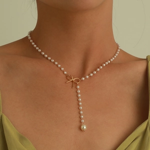 Elegante Perlenkette mit goldenem Schleifenanhänger und langer Quaste am Model