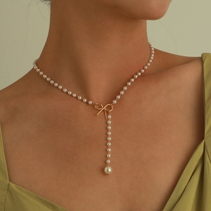 Elegante goldene Schleifenkette mit Perlenanhänger für einen minimalistischen Damenlook