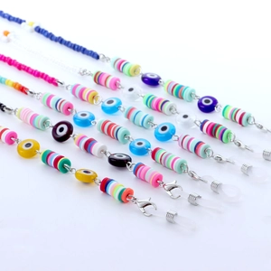 Detail van kleurrijke heishi en evil eye kralen op bohemien bril- en maskerkettingen