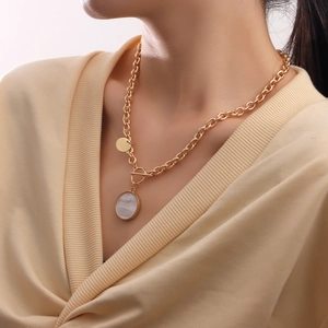Golden punk chain necklace with mother of pearl pendants and T-bar closure on a model