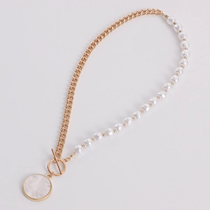 Detail of gold chain necklace with white pearls, OT toggle clasp, and marble pendant