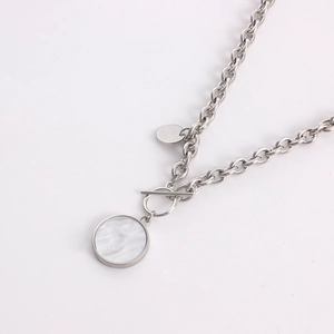 Detail of silver toggle clasp chain with white marble pendant and metal tag