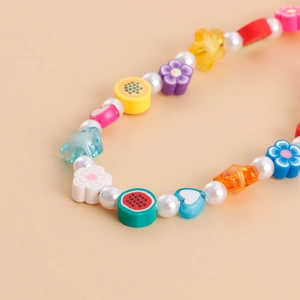 Détails de la lanière en perles arc-en-ciel avec formes de fruits et cœurs colorés