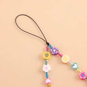 Détail de la dragonne de téléphone en perles colorées avec fleurs et breloques en cœur