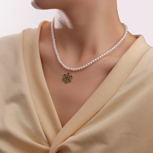 Christmas pearl necklace with snowflake pendant worn by a model in a beige sweater