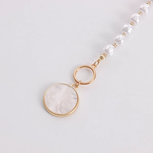 Macro shot of gold OT buckle necklace with pearls and white marble pattern pendant