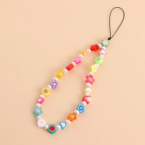 Détail des perles de fruits colorées et des perles sur une lanière de téléphone portable