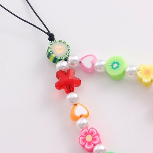 Gros plan détaillé d'un bijou de téléphone Y2K perlé avec fleurs et fruits en acrylique