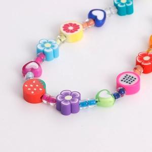 Détail de perles colorées avec fleurs, cœurs et tranches de fruits pour mobile