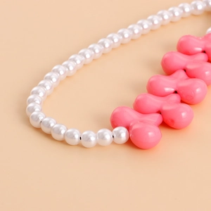 Detail of pink acrylic heart beads and white faux pearls on a stylish phone charm strap