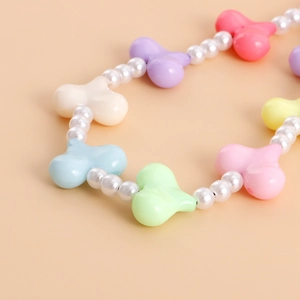 Macro shot of colorful macaron heart beads and round pearls with smooth resin finish