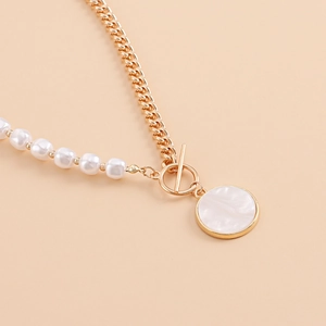 Detail of necklace with gold chain, white pearls and mother-of-pearl pendant with OT clasp