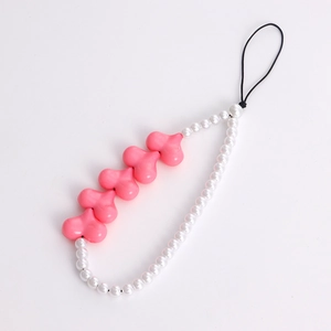 Close-up of pink heart-shaped beads and white pearls on a sweet phone charm strap