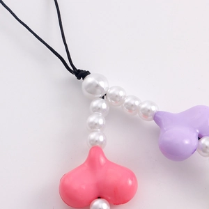 Close-up of pink and purple acrylic heart beads and pearls on the cute phone charm