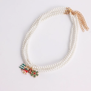 Macro view of triple-layer pearl necklace featuring Christmas bells and tree charms